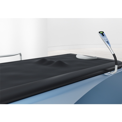 Powierzchnia robocza łóżka Wellsystem Medical z poduszką i pilotem sterującym.