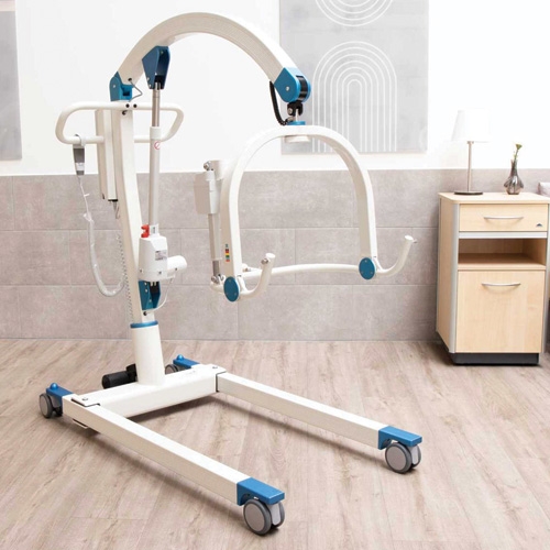 Podnośnik transportowo kąpielowy Carlo Alu Comfort EP 230 w pomieszczeniu z jasną podłogą i szarą ścianą.