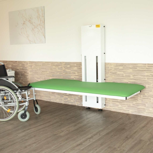 Składany stół pielęgnacyjny ANA z zielonym materacem i dostępem dla wózka inwalidzkiego.