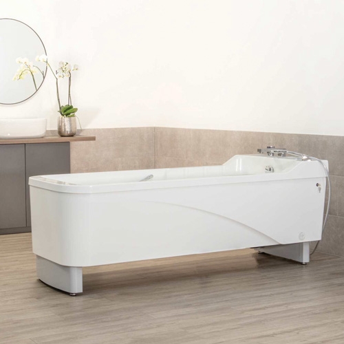 Wanna rehabilitacyjna Avero Viva Plus w eleganckim gabinecie kąpielowym z beżowymi kaflami i umywalką.